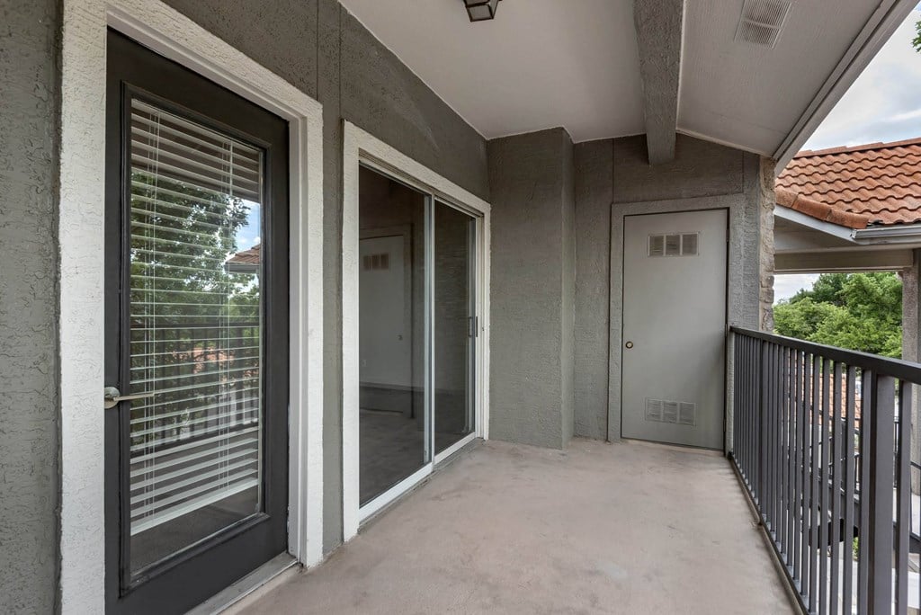 a covered balcony with a door to a room on the side